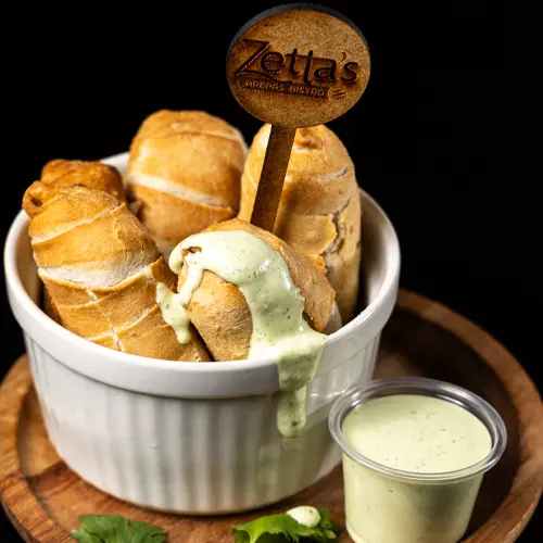 Close-up of a crispy tequeño, a popular Venezuelan snack filled with melted cheese